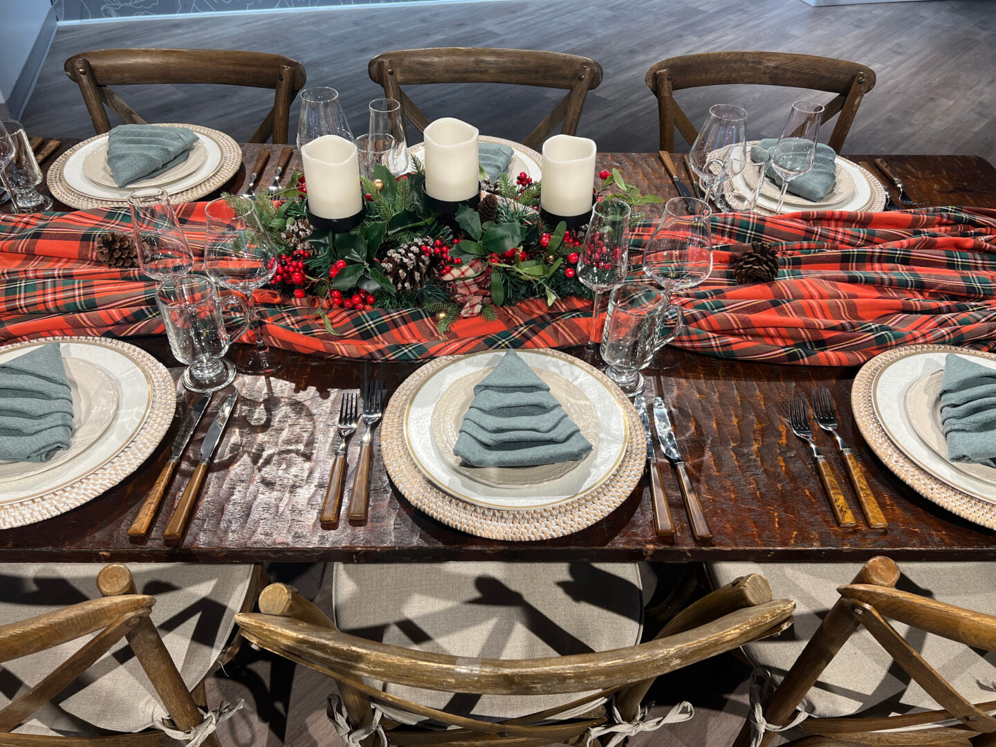Rustic Holiday Table setting with Farm Table with plaid linen down center and six table settings.
