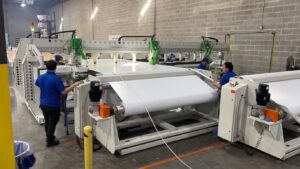 Select Event Group team members operating the Miller Weldmaster Moduline during vinyl manufacturing production
